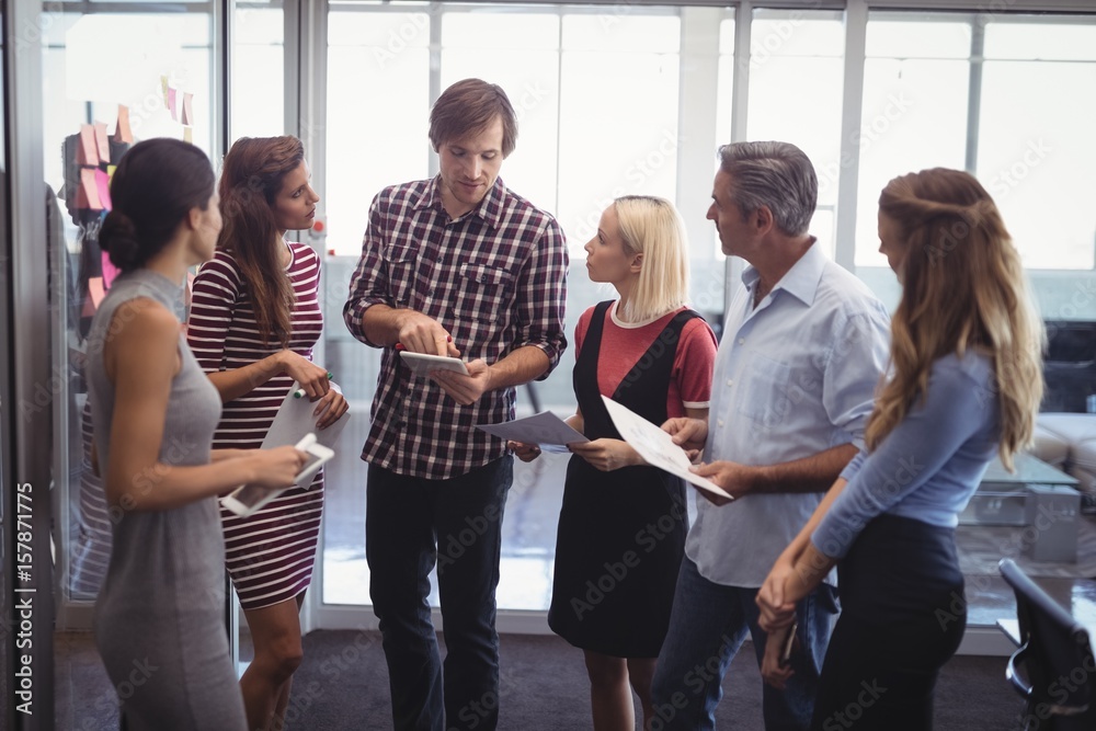 Naklejka premium Businessman discussing strategies with team in creative office