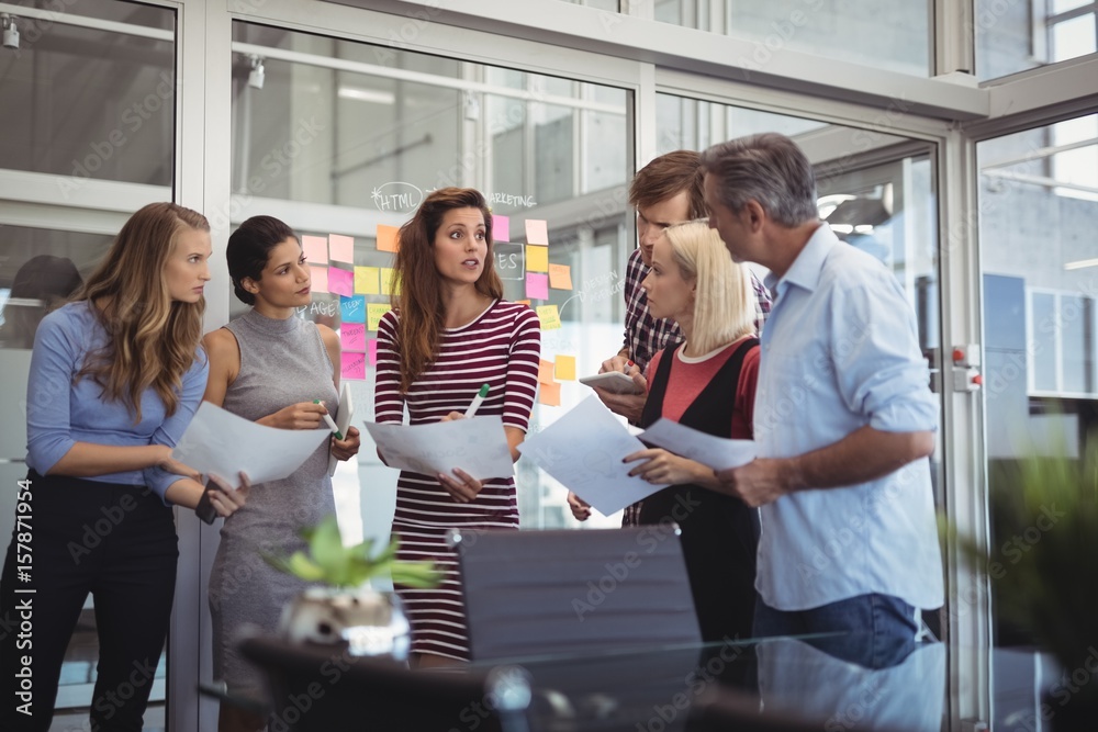 Business people with papers having discussion in creative office Business people with papers having discussion in creative office