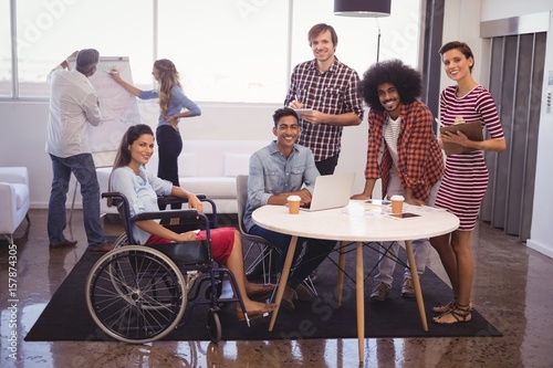 Bild auf Leinwand Handicap female executive with colleagues in creative office