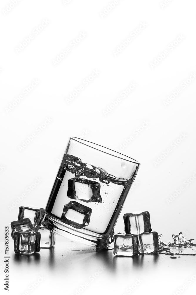 Cube of ice thrown into a glass with liquid Cube of ice thrown into a glass with liquid