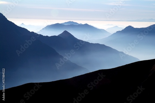 Принти на полотні The ridges of the lake follow each other in the direction of the Po Valley with the mist to accentuate the vastness of the scenery