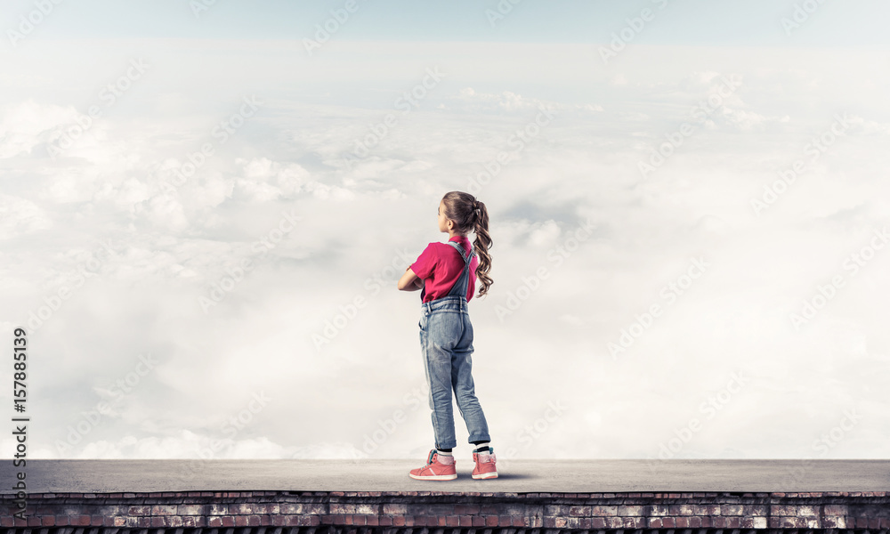 Concept of careless happy childhood with girl looking far away Concept of careless happy childhood with girl looking far away