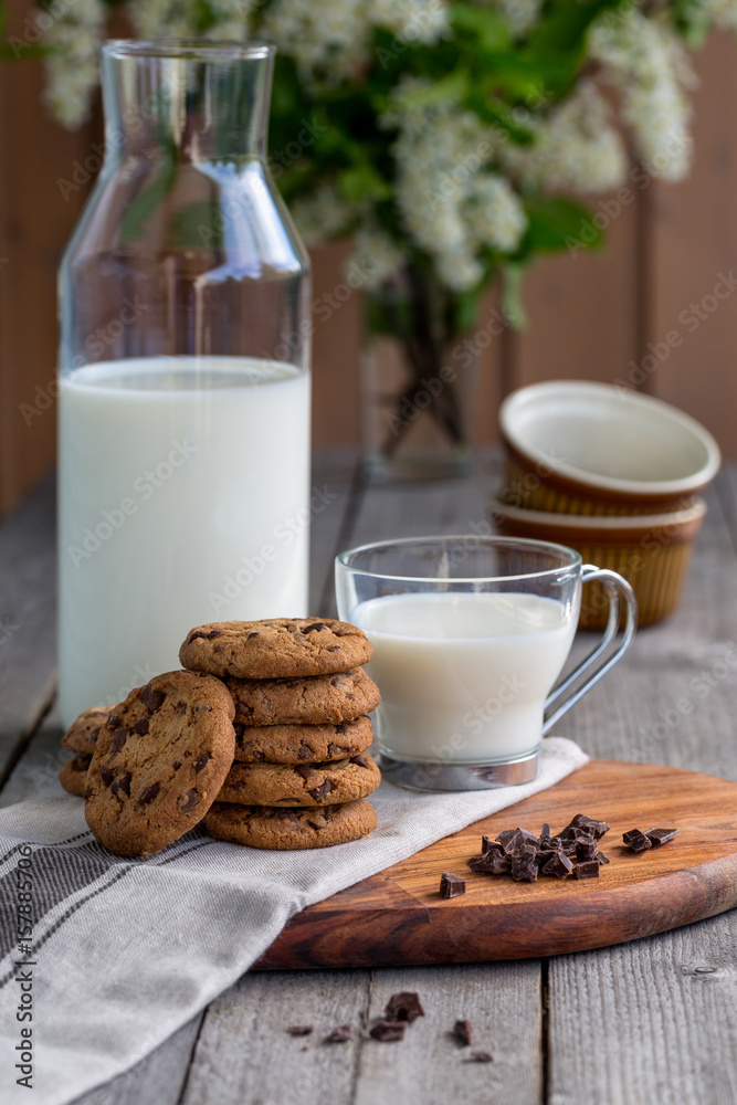 Chocolate chip cookies with milk on old rustic wooden table Chocolate chip cookies with milk on old rustic wooden table