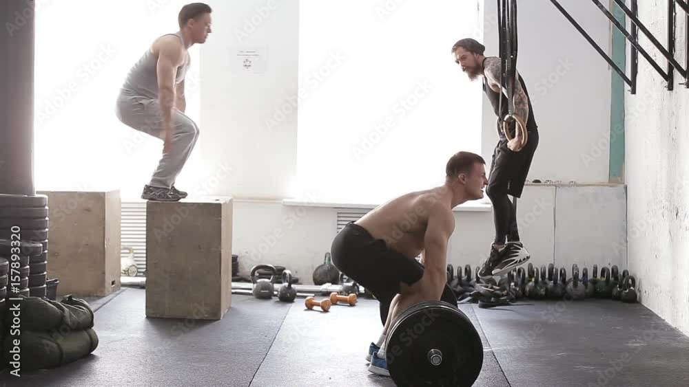 muscular male crossfit training. athletes train in the gym