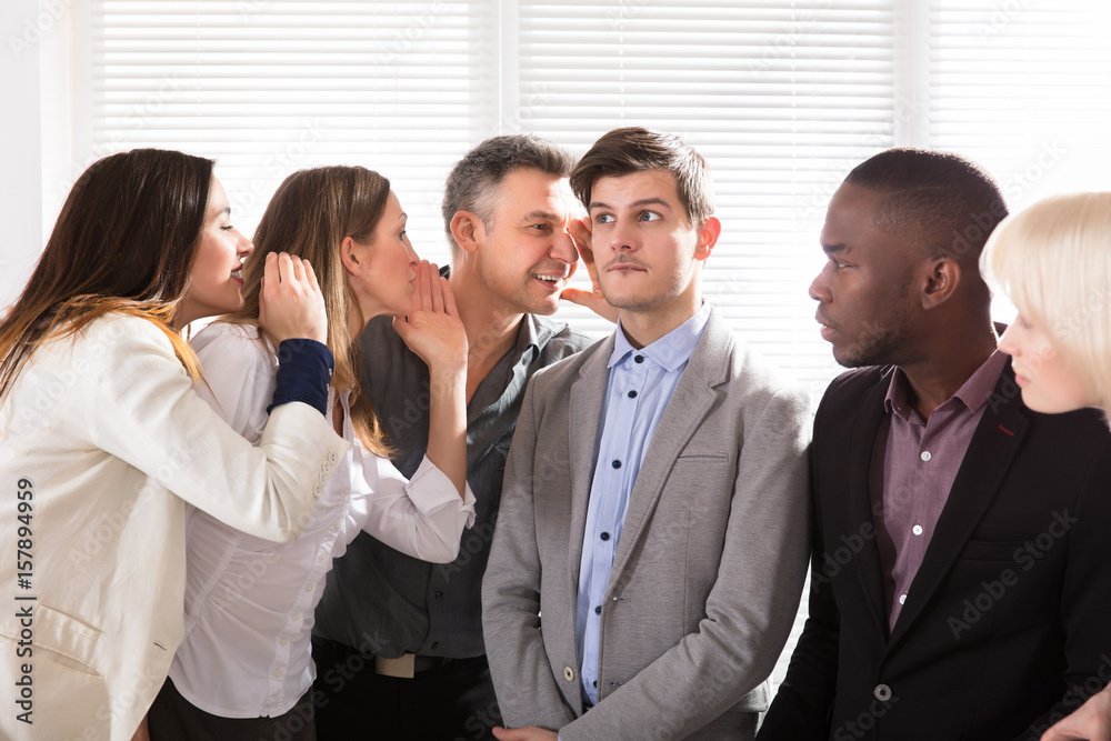 Business Colleagues Whispering In The Office Business Colleagues Whispering In The Office