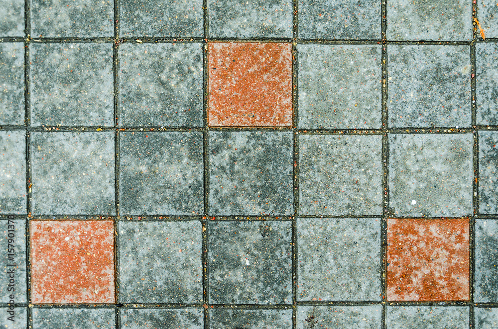 Fototapeta premium Gray concrete pavings on a sidewalk with red elements stones. Abstract background texture