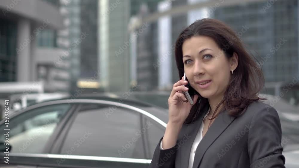 A young successful woman in a suit emerged from the office to the street to call for personal reasons. She leads a pleasant conversation. HD 1920x1080 A young successful woman in a suit emerged from the office to the street to call for personal reasons. She leads a pleasant conversation. HD 1920x1080