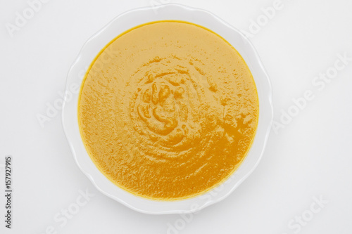 Plate of pea cream soup on white background