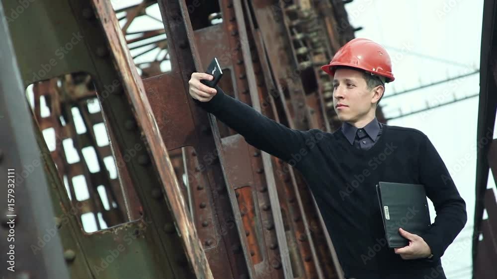 Construction engineer in helmet makes selfie on the phone Construction engineer in helmet makes selfie on the phone