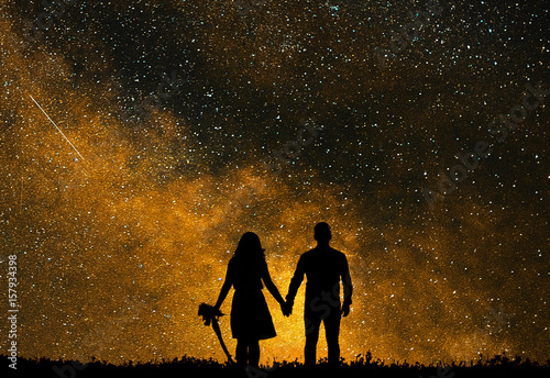 The silhouette of lovers against the backdrop of bright golden star. Love watching the sky. photo