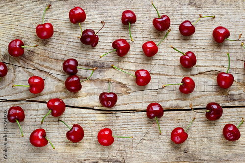top view  fresh ripe red cherries on  rustic wood board background