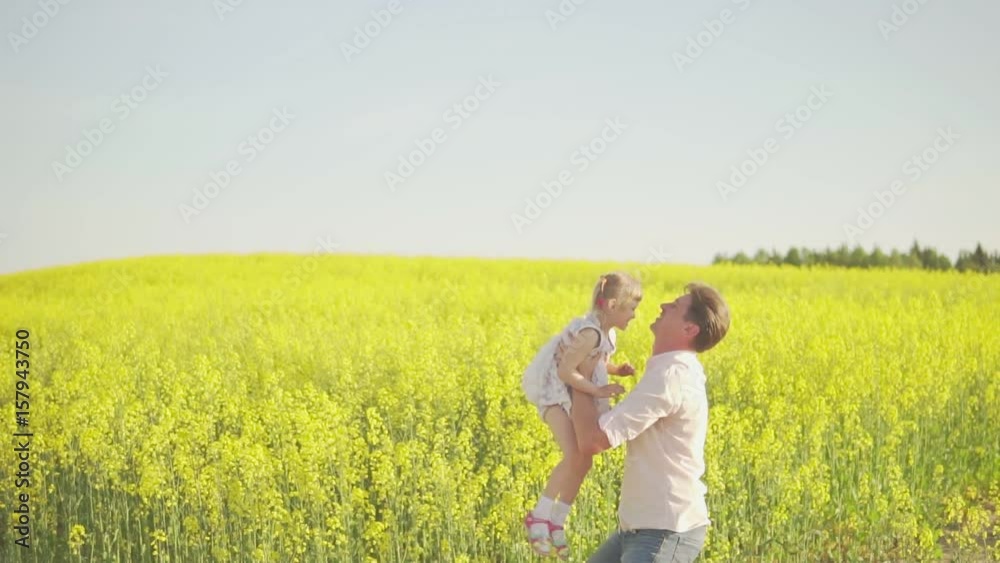 Dad throws a daughter on a rapeseed field Dad throws a daughter on a rapeseed field