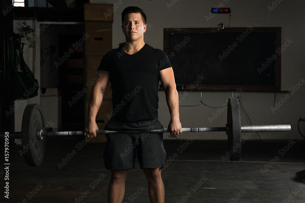 Active man doing a barbell deadlift Active man doing a barbell deadlift