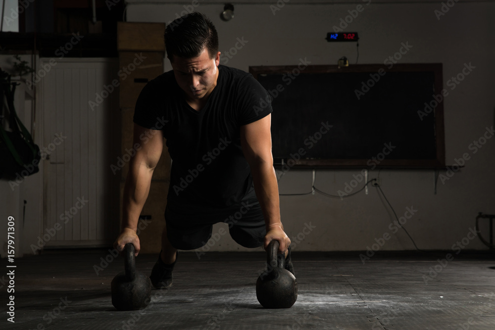 Naklejka premium Athletic man doing push-ups in a gym