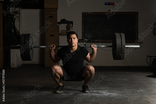 Athletic man donig barbell squats