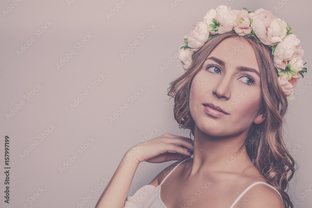 Beautiful girl with vintage flowers on her head on a white background close-up.