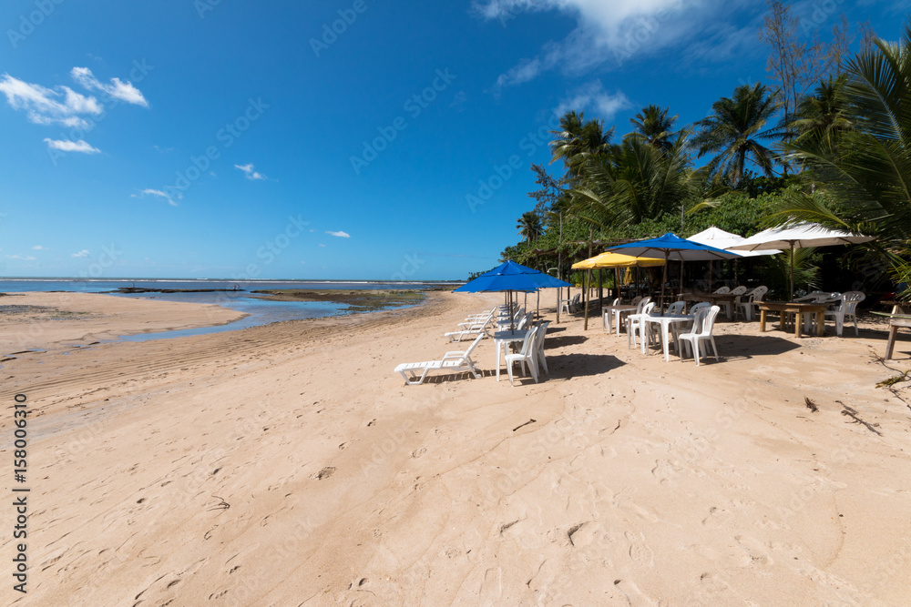 Umbrella and beach chairs on tropical paradise island