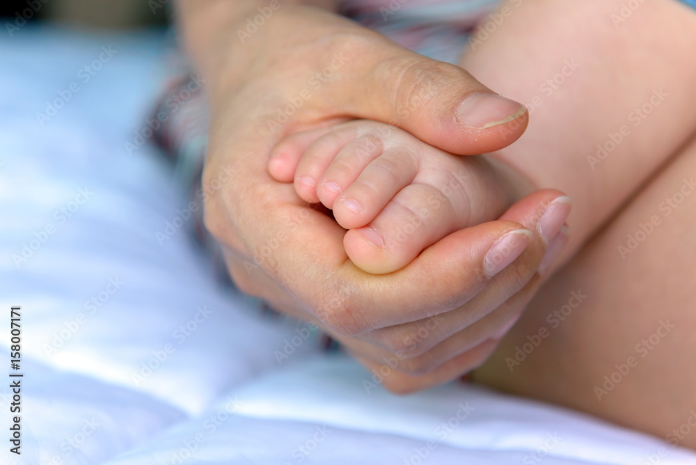 Asian baby feet in mother hands. boy little 7 months old Asian baby feet in mother hands. boy little 7 months old