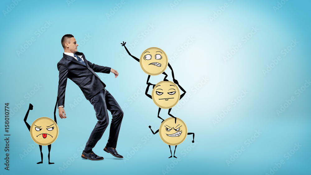 Φωτογραφία A businessman losing his balance while many large golden coins with arms and legs are trying to make him fall