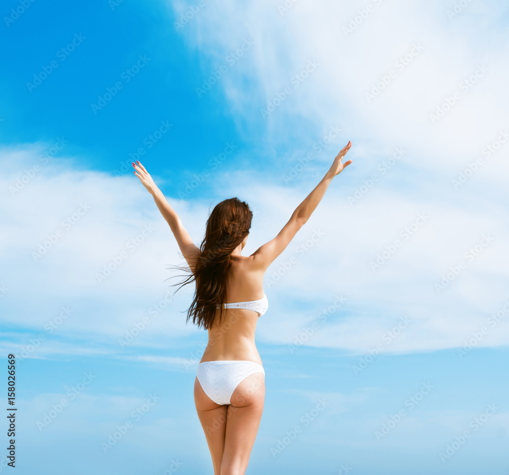 Beautiful woman in white bikini. Young and sporty girl posing on a beach at summer. Beautiful woman in white bikini. Young and sporty girl posing on a beach at summer.