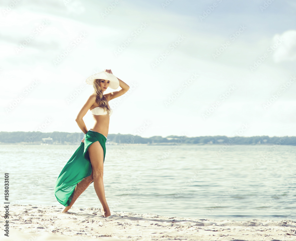 Beautiful, attractive, sexy and young girl in a hat and white bikini with green silk posing on a beach. Traveling, vacation, concept. Beautiful, attractive, sexy and young girl in a hat and white bikini with green silk posing on a beach. Traveling, vacation, concept.