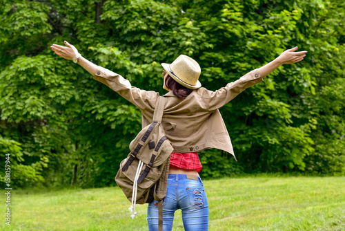 Beautiful Freedom traveler woman standing with raised arms and enjoying a beautiful nature. Travel concept