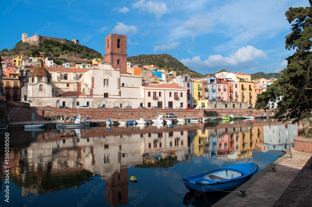 The town of Bosa on the island of Sardinia. Waterfront with colorful houses and a small wooden boat.