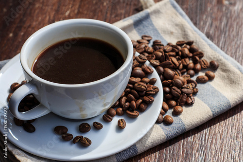 coffee cup and beans on the wood background.