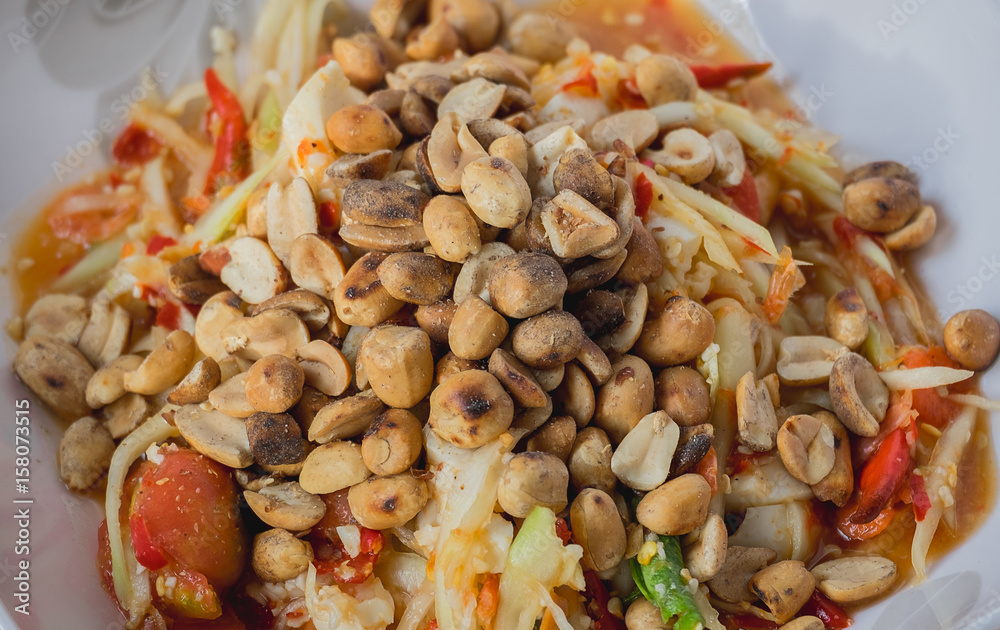 Papaya salad garnished with nuts.