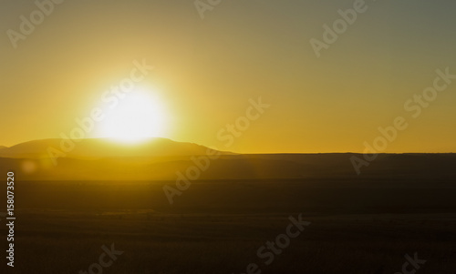 The sun sets over the hill above the valley © vagon
