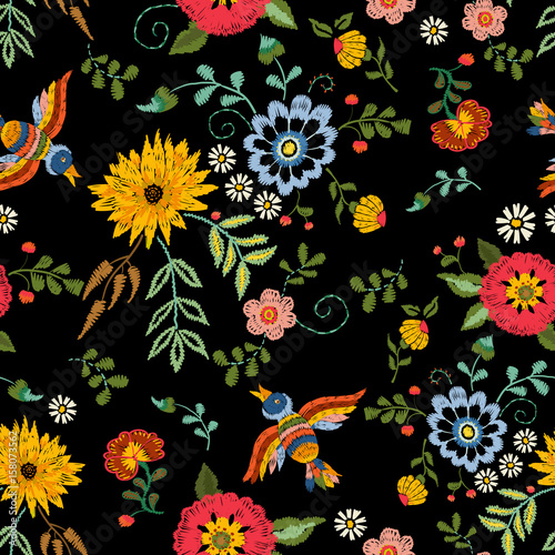 Embroidery ethnic seamless pattern with birds and fantasy flowers. Vector embroidered traditional floral design for fashion fabric.
