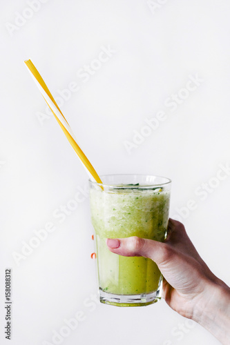 Woman holds a glass with green cocktail