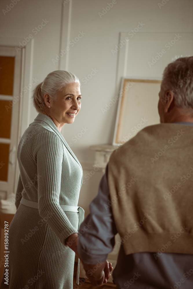 Fototapeta premium senior husband and wife holding hands and looking at each other at home