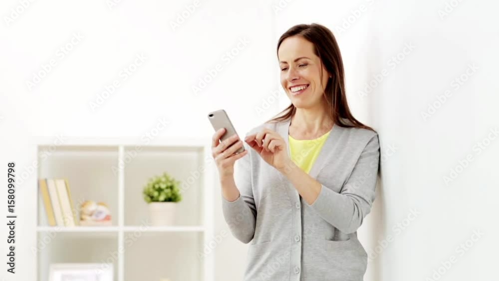 happy woman texting message on smartphone at home happy woman texting message on smartphone at home