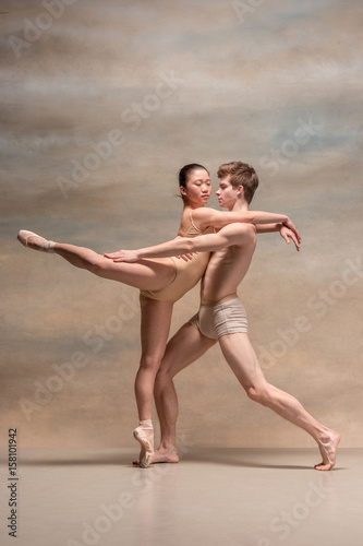 Couple of ballet dancers posing over gray background © master1305
