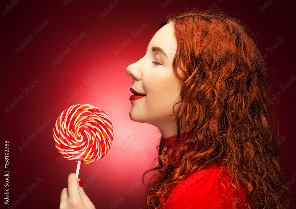 Pretty young woman holding lolly pop.