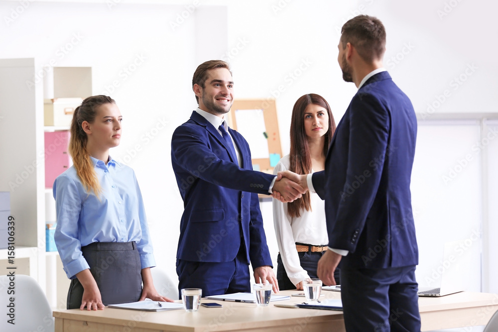 Employer and applicant shaking hands after interview Employer and applicant shaking hands after interview