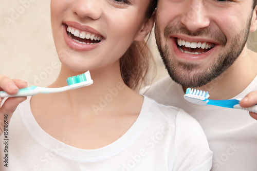 Young happy couple brushing...
