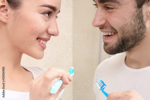 Young happy couple brushing...
