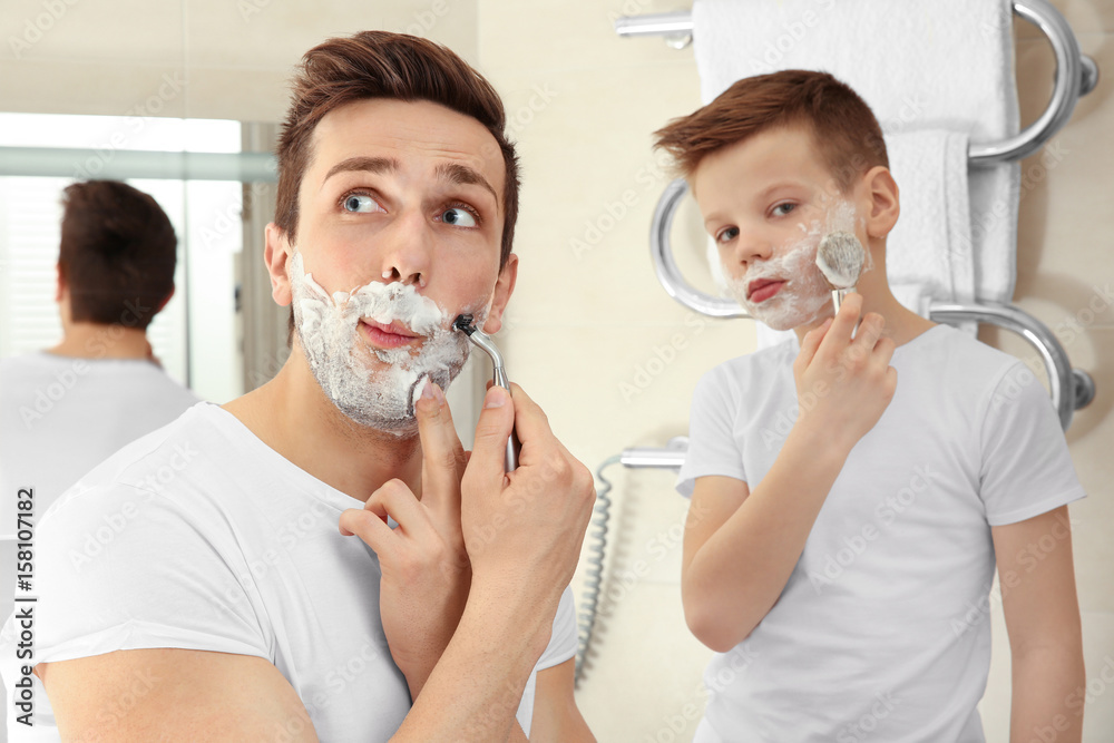 Father and son shaving in bathroom