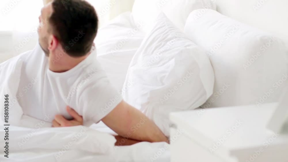 man waking up in bed at home man waking up in bed at home