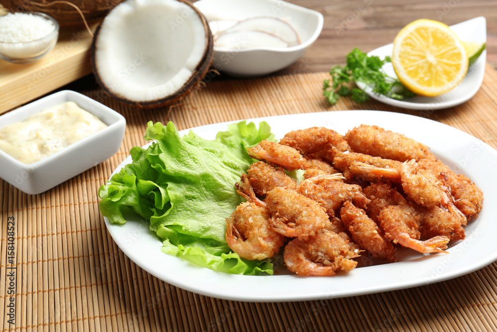 Plate with delicious coconut shrimps on table Plate with delicious coconut shrimps on table