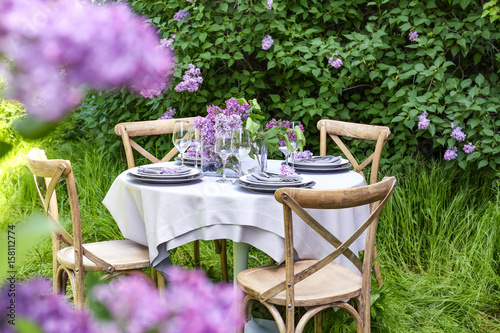 Table setting for dinner in beautiful lilac garden