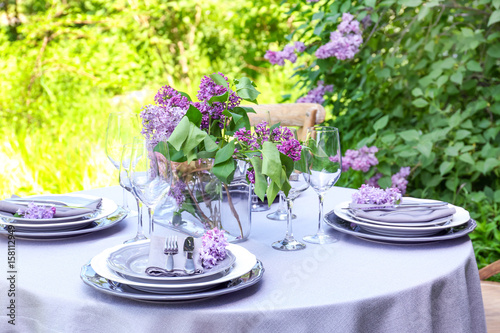 Table setting for dinner in beautiful lilac garden