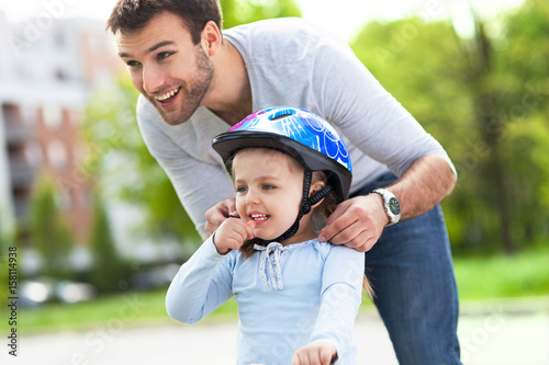 Girl learning to ride a bicycle with father
 photo