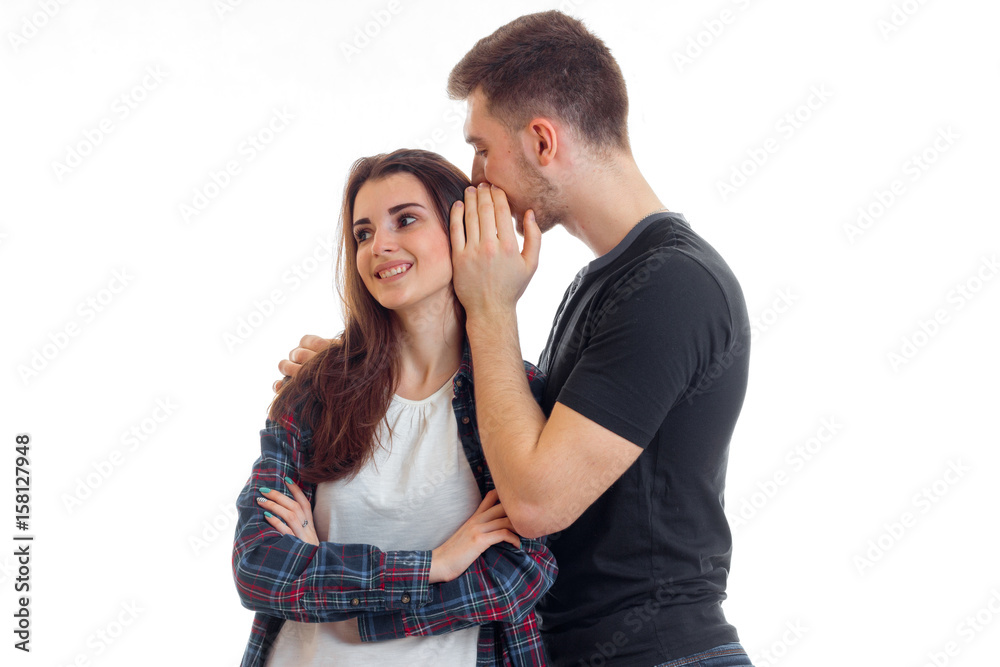young guy says the word in the ear of his girlfriend smiling young guy says the word in the ear of his girlfriend smiling