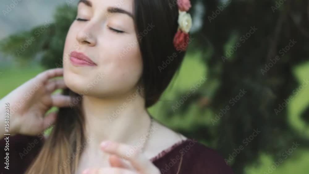 Relaxed young woman with head wreath sitting in a park Relaxed young woman with head wreath sitting in a park