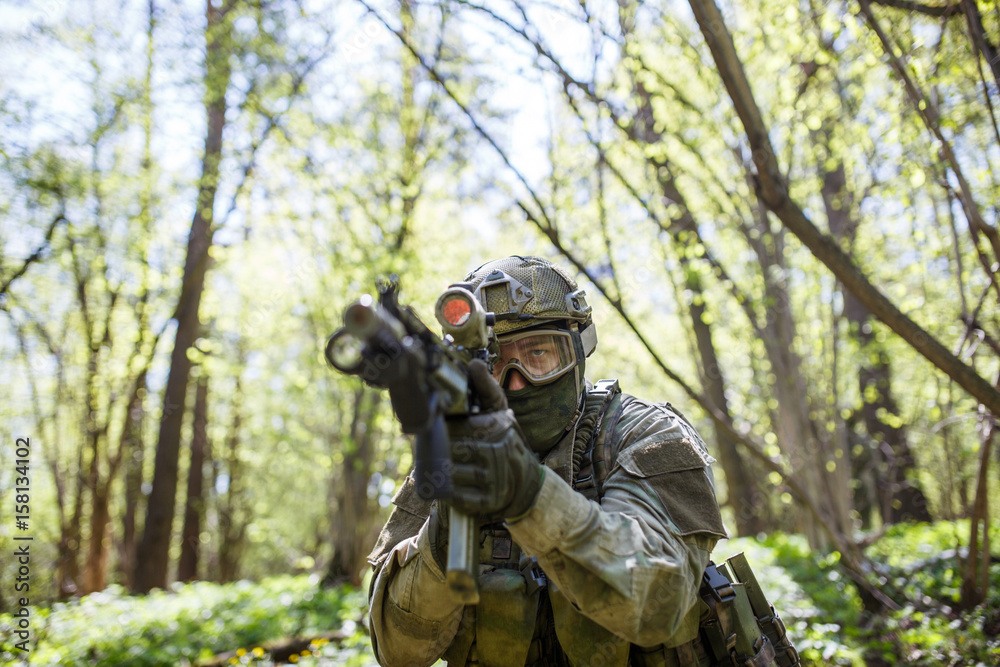 Military man aiming holding gun