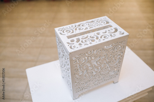 White chest with original design stands on a little table © myronovychoksana