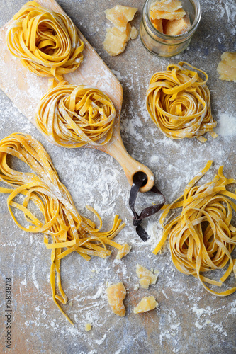 Raw tagliatelle pasta homemade and cutting board